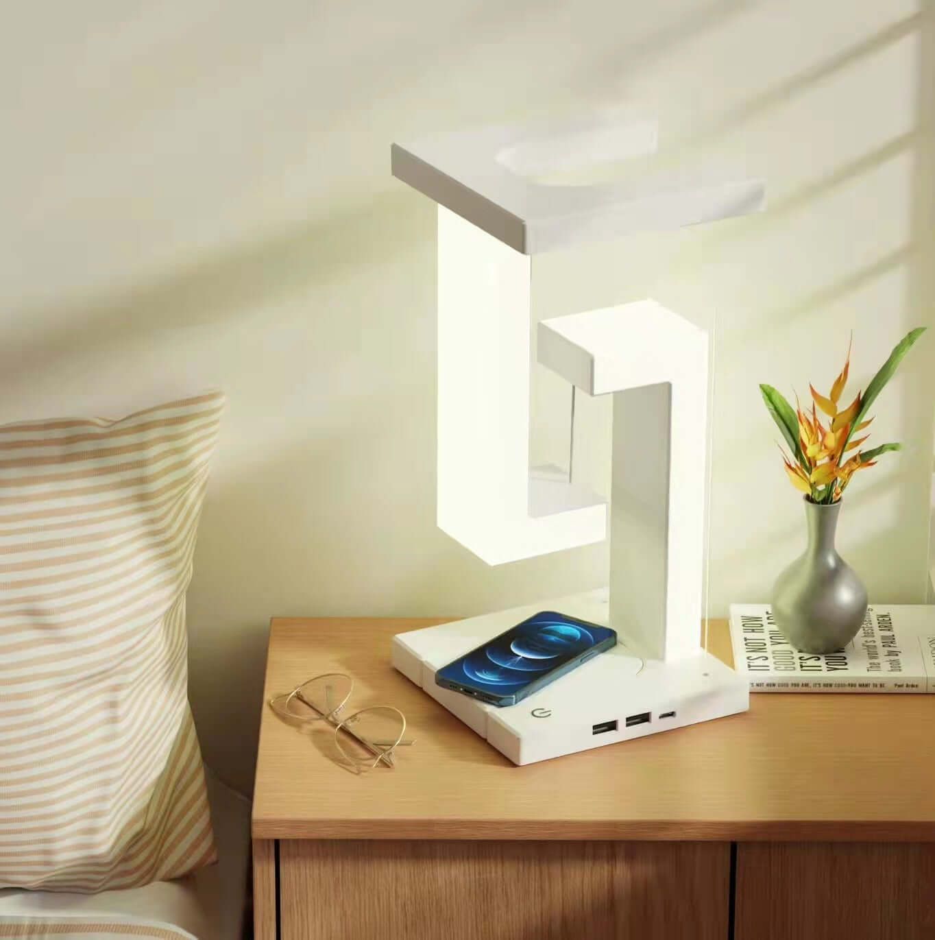 Creative Floating Balance Lamp with wireless phone charging on a stylish nightstand.