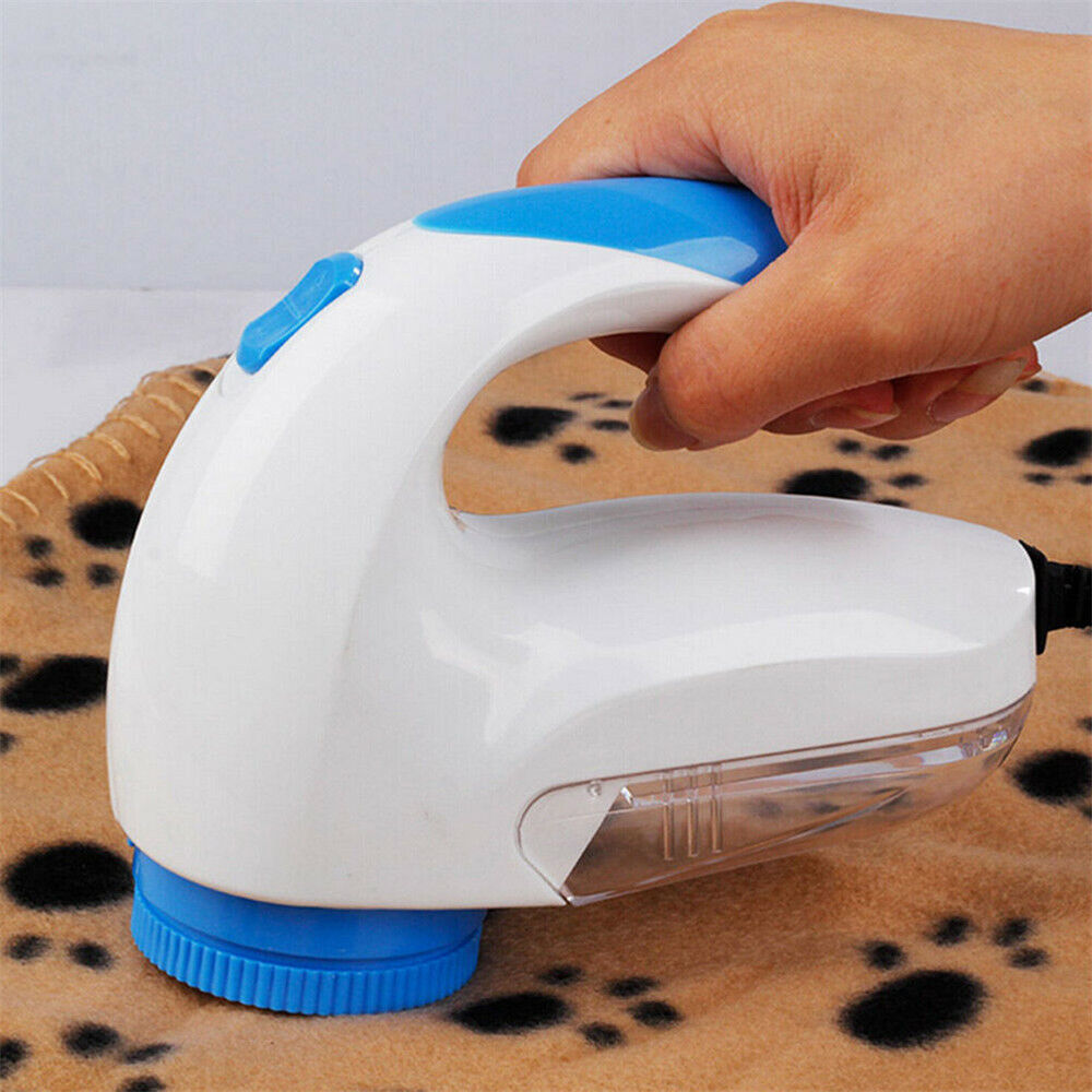 Electric lint remover in use on a soft blanket, designed to remove fuzz and lint easily and efficiently.