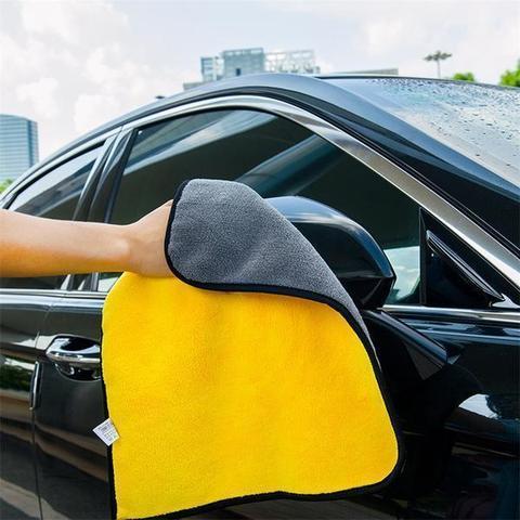 Person using two-color dual-use cleaning towel to clean car exterior, ensuring a clean, scratch-free finish.