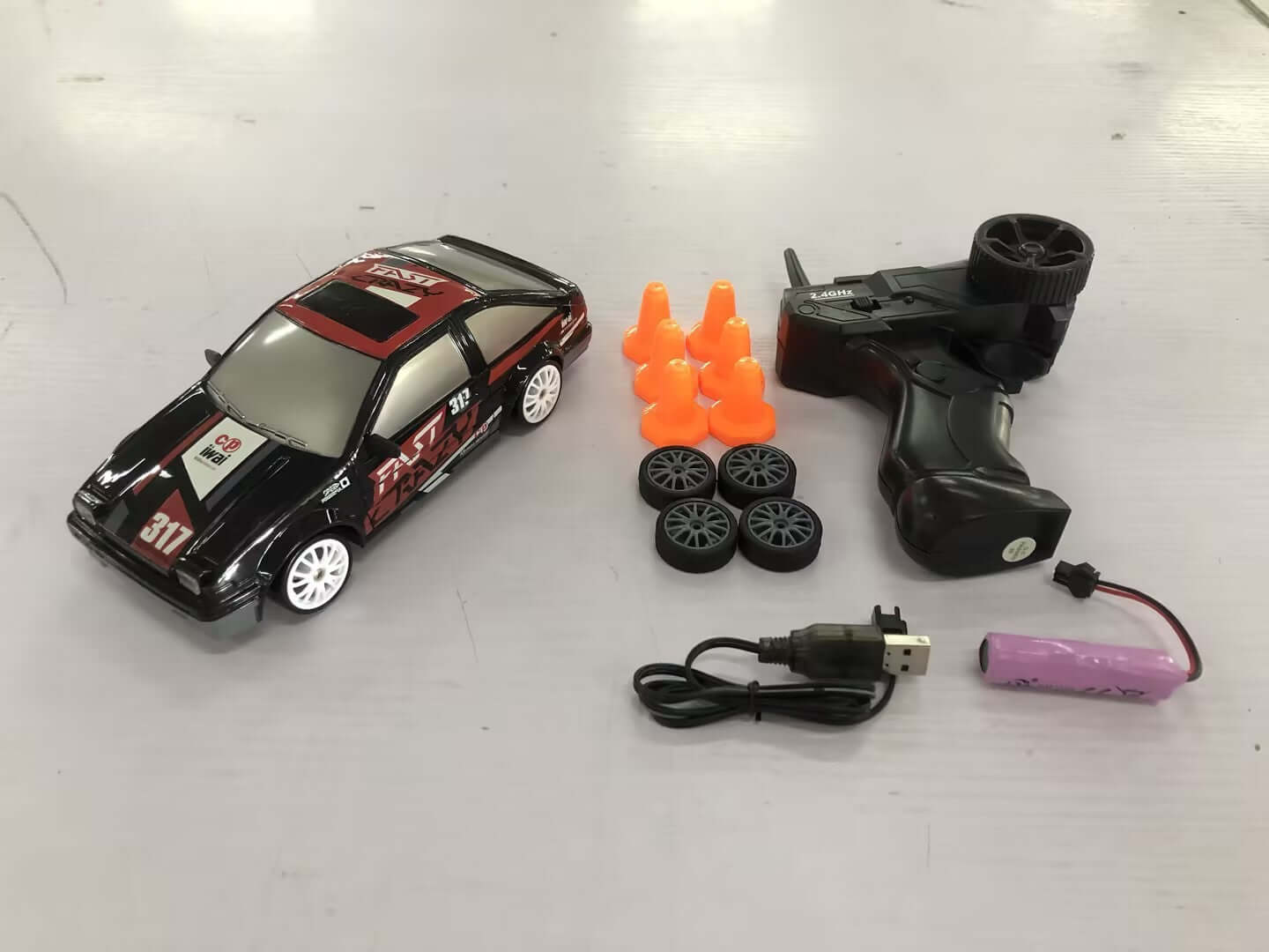 Remote Control Drift Racing Car with accessories including cones, wheels, remote, and rechargeable battery.