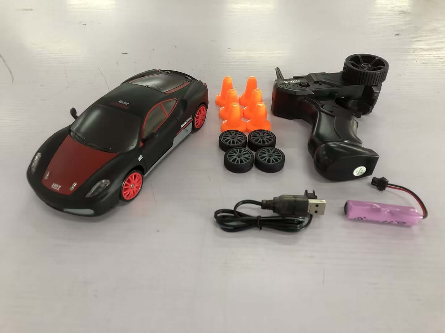 Remote Control Drift Racing Car with controller, racing cones, spare tires, and charging cable.