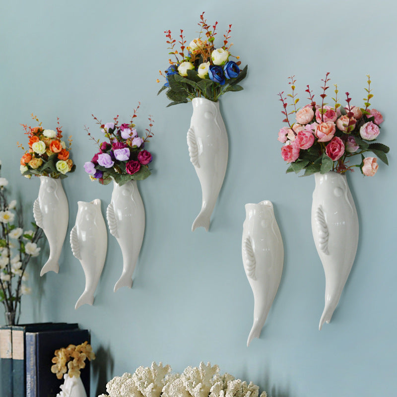 Simple Modern Creative Wall decoration with white ceramic goldfish vases holding colorful flowers.