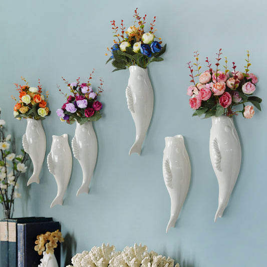 Simple Modern Creative Wall decoration with white ceramic goldfish vases holding colorful flowers.