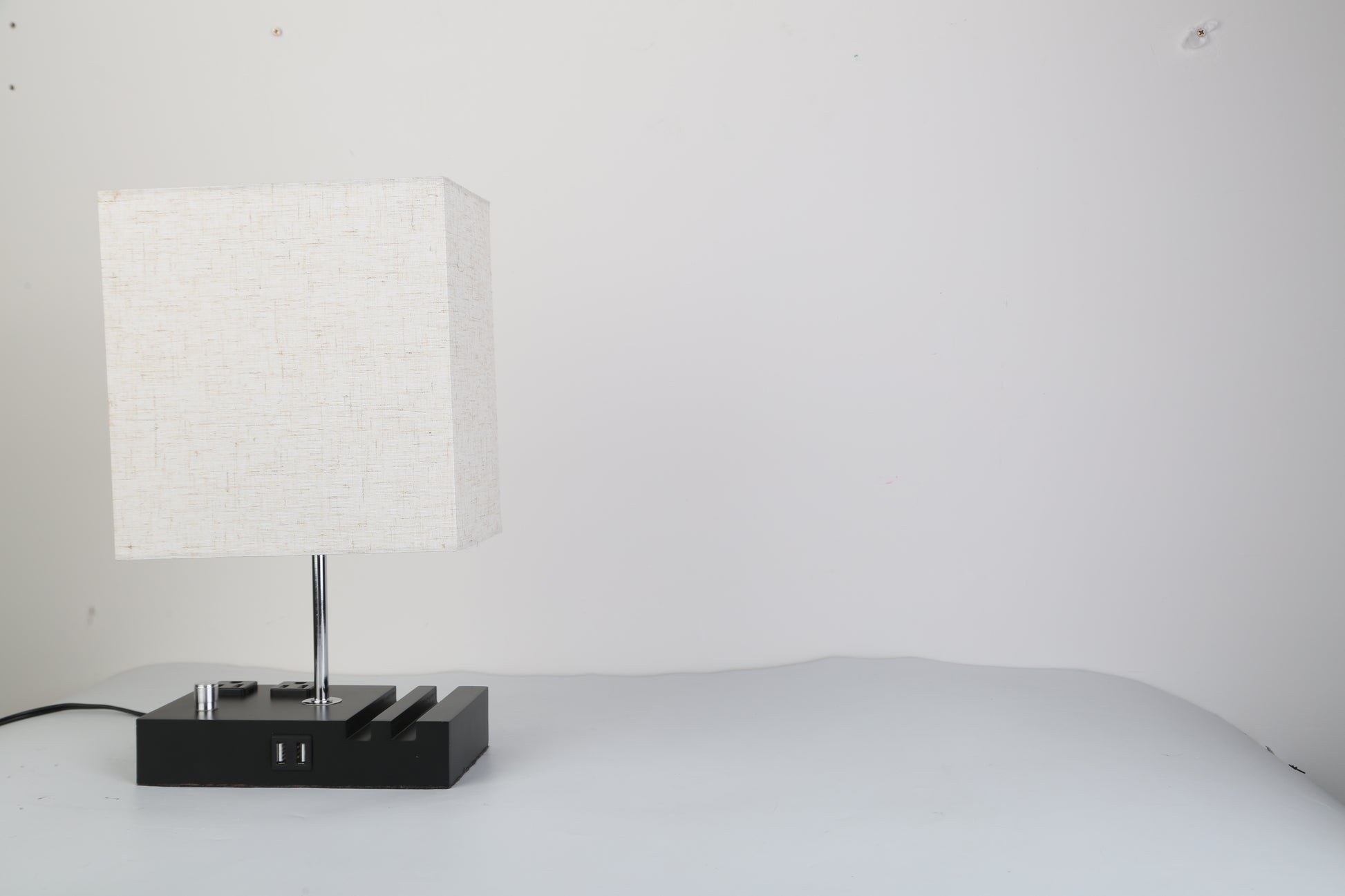 Fully dimmable table lamp with USB ports and power outlets on a minimalist wooden base.