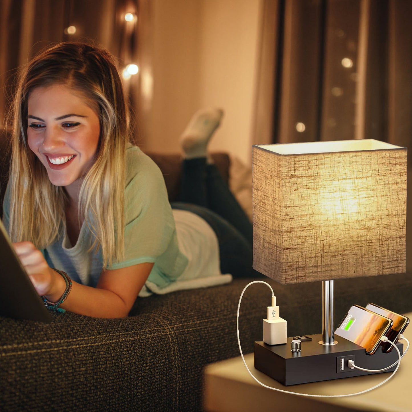Fully dimmable table lamp with USB ports and power outlets beside a woman using a tablet on a couch.