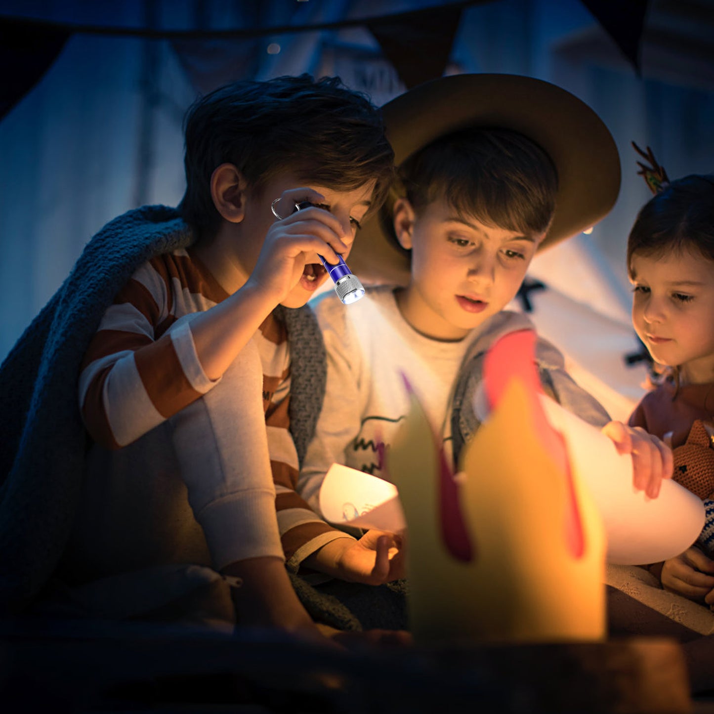 Children using an emergency flashlight while creating a cozy atmosphere, enjoying activities during dark evenings.